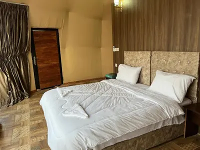 a bedroom with a large bed with white sheets and pillows at Bright Stars Camp in Disah