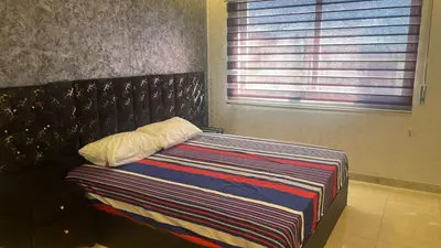 a bed in a room with a window at الروف سوبر ديلوكس 2 غرف نوم صالة جلوس و طعام مكيفة للإيجار in Amman