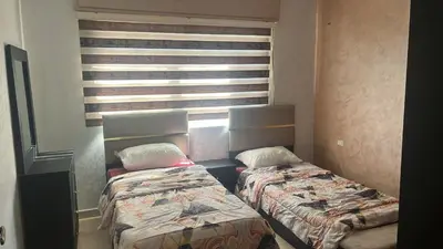 two beds in a small room with a window at الروف سوبر ديلوكس 2 غرف نوم صالة جلوس و طعام مكيفة للإيجار in Amman