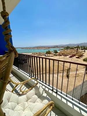 a balcony with a chair and a view of a beach at Aladdin Chalet 15 in Aqaba