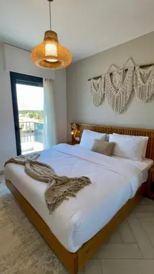 a bedroom with a large bed with a blanket on it at Aladdin Chalet 15 in Aqaba