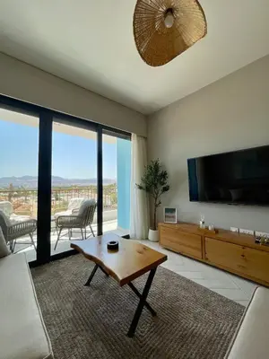 a living room with a television and a table at Aladdin Chalet 15 in Aqaba
