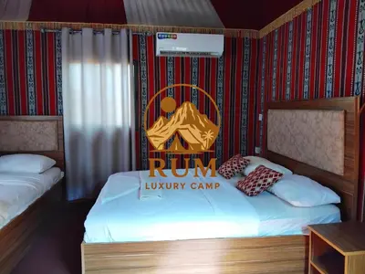 a room with a run luxury camp sign on the bed at RUM LUXURY CAMp in Wadi Rum