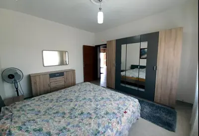 a bedroom with a bed and a dresser and a mirror at Ayyash in Amman