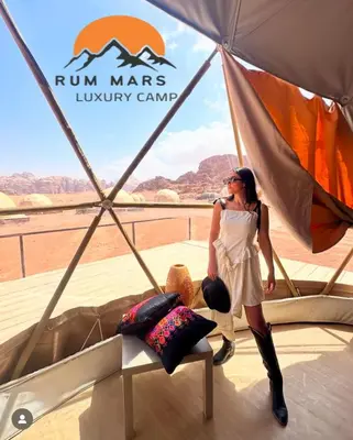 a woman is standing inside of a tent at RUM MARS lUXURY CAMP in Wadi Rum