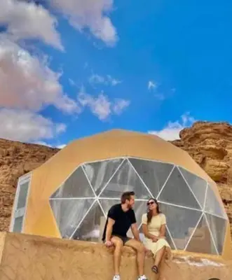 a man and a woman sitting in a tent at RUM MARS lUXURY CAMP in Wadi Rum