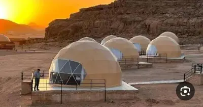 a group of domes in a desert with a man standing in front at RUM MARS lUXURY CAMP in Wadi Rum