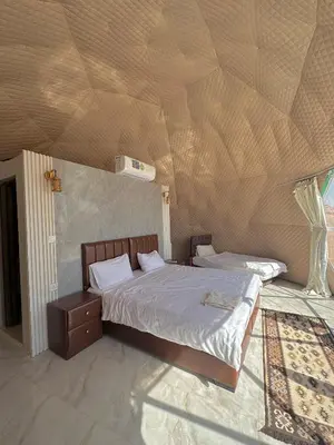 two beds in a bedroom with a wooden ceiling at RUM MARS lUXURY CAMP in Wadi Rum