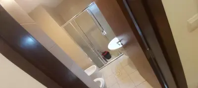 a bathroom with a toilet and a glass shower at Alraha village-aqaba قرية الراحة- مرسى زايد -العقبة in Aqaba
