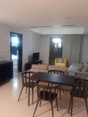 a living room with a table and chairs and a couch at Elegant Apartment in Amman