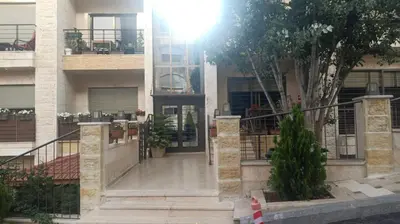 an apartment building with a staircase leading to the front door at Elegant Apartment in Amman