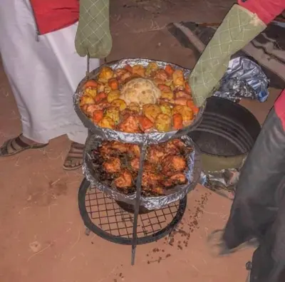 a person is cooking food on a grill at Wadi Rum Bedouin Story Camp & Tours in Wadi Rum