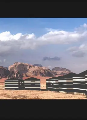 a black and white fence in the middle of the desert at Wadi Rum Bedouin Story Camp & Tours in Wadi Rum