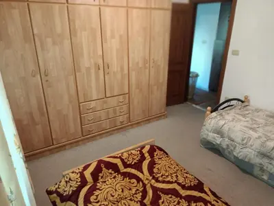 a bedroom with a bed and a rug on the floor at Said in Amman