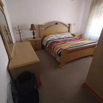 a bedroom with a bed and a dresser and a desk at Said in Amman
