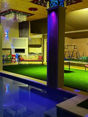 a house with a swimming pool with purple lights at مزرعة ريفان in Dawqarah