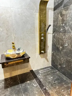 a bathroom with a shower with a sink at مزرعة ريفان in Dawqarah