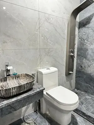 a bathroom with a toilet and a sink at مزرعة ريفان in Dawqarah