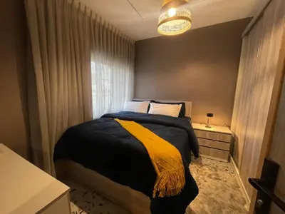 a bedroom with a bed with a yellow blanket at Hawari Group in Amman