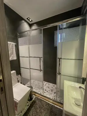 a bathroom with a shower with a toilet and a sink at Hawari Group in Amman
