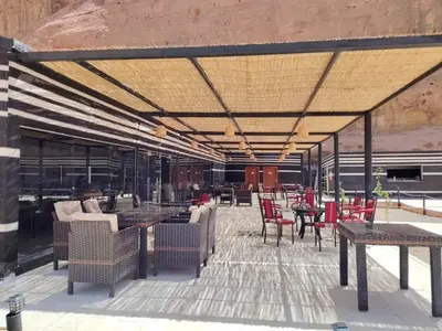 an outdoor patio with tables and chairs and tablesktop at Eagle Rum Camp in Disah