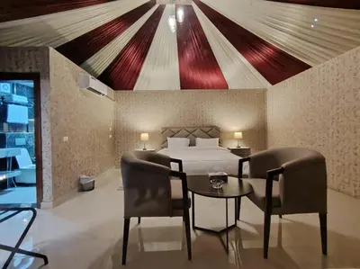 a bedroom with a bed and a table and chairs at Eagle Rum Camp in Disah