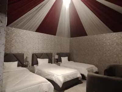 a room with two beds and a wall with at Eagle Rum Camp in Disah