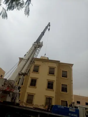 a crane on top of a yellow building at أبو راشد للشقق المفروشه in Aqaba