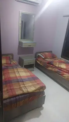 two beds sitting in a room with a mirror at أبو راشد للشقق المفروشه in Aqaba