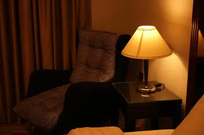 a lamp sitting on a table next to a chair at Alqalah Restotel فندق ومطعم القلعة in Kerak