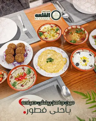 a wooden table with plates of food on it at Alqalah Restotel فندق ومطعم القلعة in Kerak