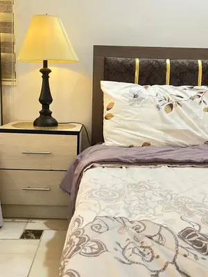 a bedroom with a bed with a lamp on a night stand at Jerash Gate in Jerash