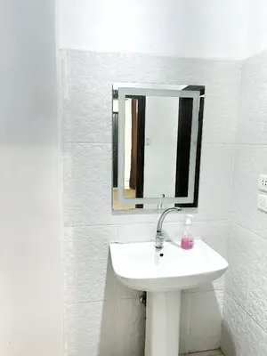 a white bathroom with a sink and a mirror at Jerash Gate in Jerash