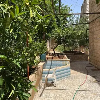 a swimming pool with a chair in a garden at L goats house in Wadi Musa