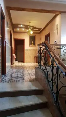 a hallway of a home with stairs and a chandelier at L goats house in Wadi Musa