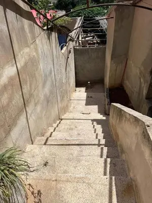 a concrete alley with stairs next to a wall at L goats house in Wadi Musa