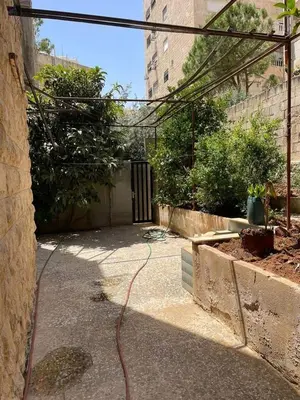 a hose is on the ground next to a building at L goats house in Wadi Musa