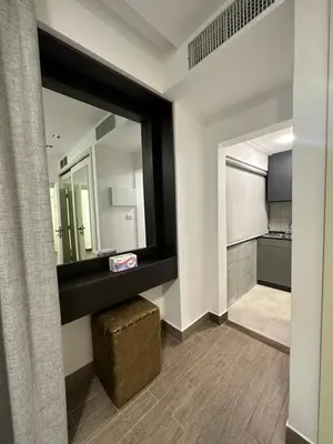 a bathroom with a large mirror and a stool at central apartment for rent 16 in Umm Uthainah