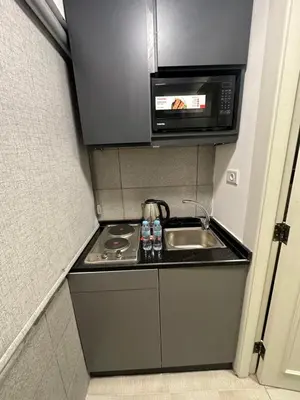 a small kitchen with a sink and a microwave at central apartment for rent 16 in Umm Uthainah