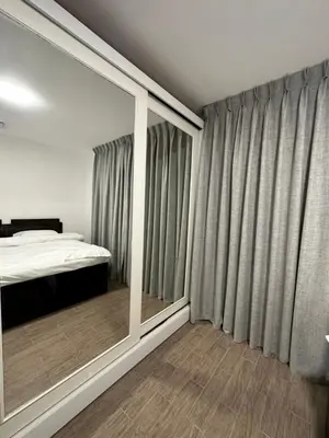 a bedroom with a bed and a large window at central apartment for rent 17 in Amman