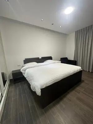 a bedroom with a large bed with white sheets at central apartment for rent 19 in Umm Uthainah