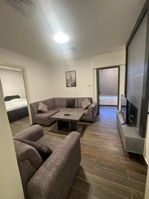 a living room with two couches and a tv at central apartment for rent 20 in Amman