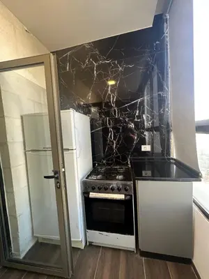 a kitchen with a stove and a refrigerator at central apartment for rent 20 in Amman