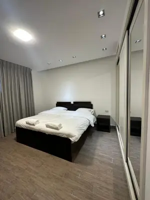 a bedroom with a bed and a large mirror at central apartment for rent 21 in Amman