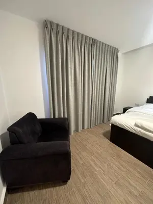 a bedroom with a chair next to a bed at central apartment for rent 21 in Amman
