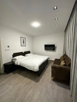 a bedroom with a large bed and a couch at central apartment for rent 23 in Umm Uthainah