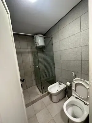 a small bathroom with a toilet and a shower at central apartment for rent 23 in Umm Uthainah