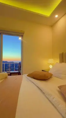 a bedroom with a large bed with a large window at Eighth Wonders Hotel in Wadi Musa