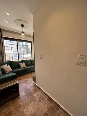 a living room with a couch and a wall at 9 Antica jabalal-lwebdeh in Amman