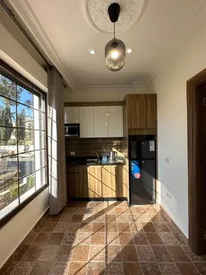 a kitchen with a large window and a black refrigerator at 9 Antica jabalal-lwebdeh in Amman